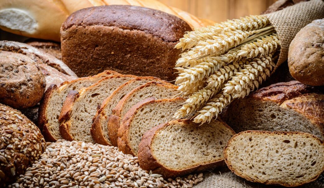Auf dem Bild diverse Backwaren, Brot und Weizenähren zu sehen,